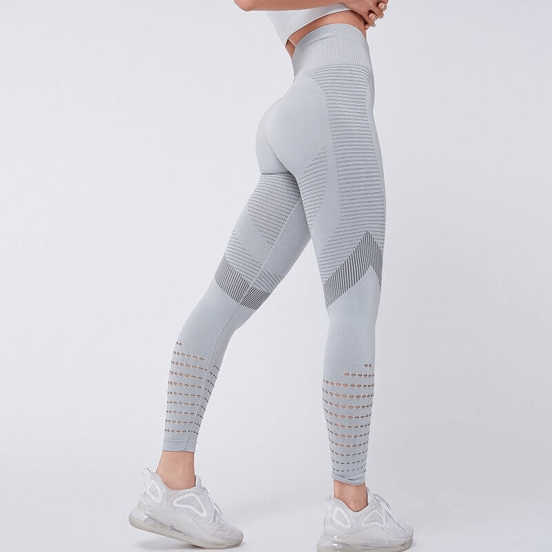 Model wearing women's hollow seamless high-waisted leggings in gray, showcasing breathable fabric and booty-lifting fit for fitness.